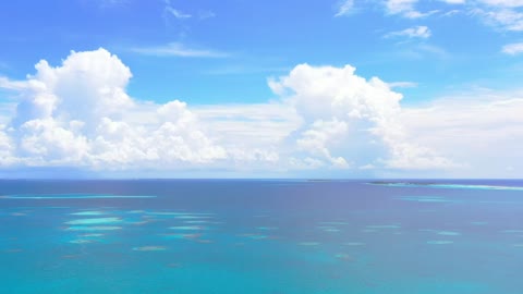 Aerial view of a blue sea with big clouds
