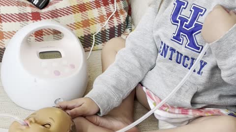 Toddler Feeds Doll With Pump