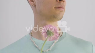 Handsome Man With Green T Shirt And Necklace Holding Flower