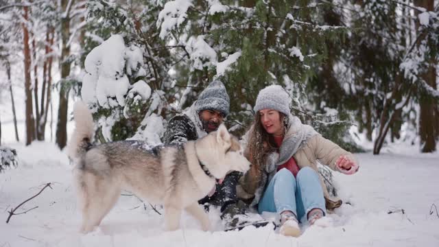 Family moment in the snow with the most beautiful dog