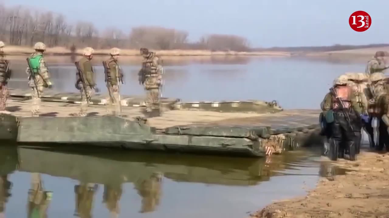Ukrainian army preparing for battle by transporting heavy artillery across river via pontoon bridge