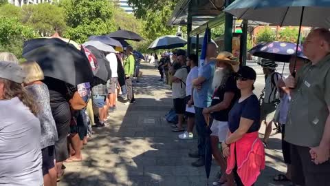 Perth Western Australia Umbrella People stand in silence at governor house today