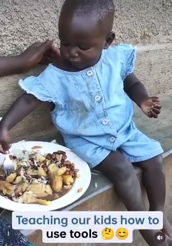 Teaching her to use cutlery
