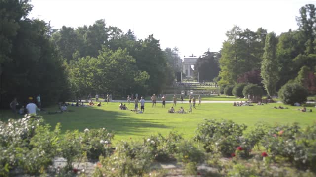 people relaxing in the city of milan sempione park