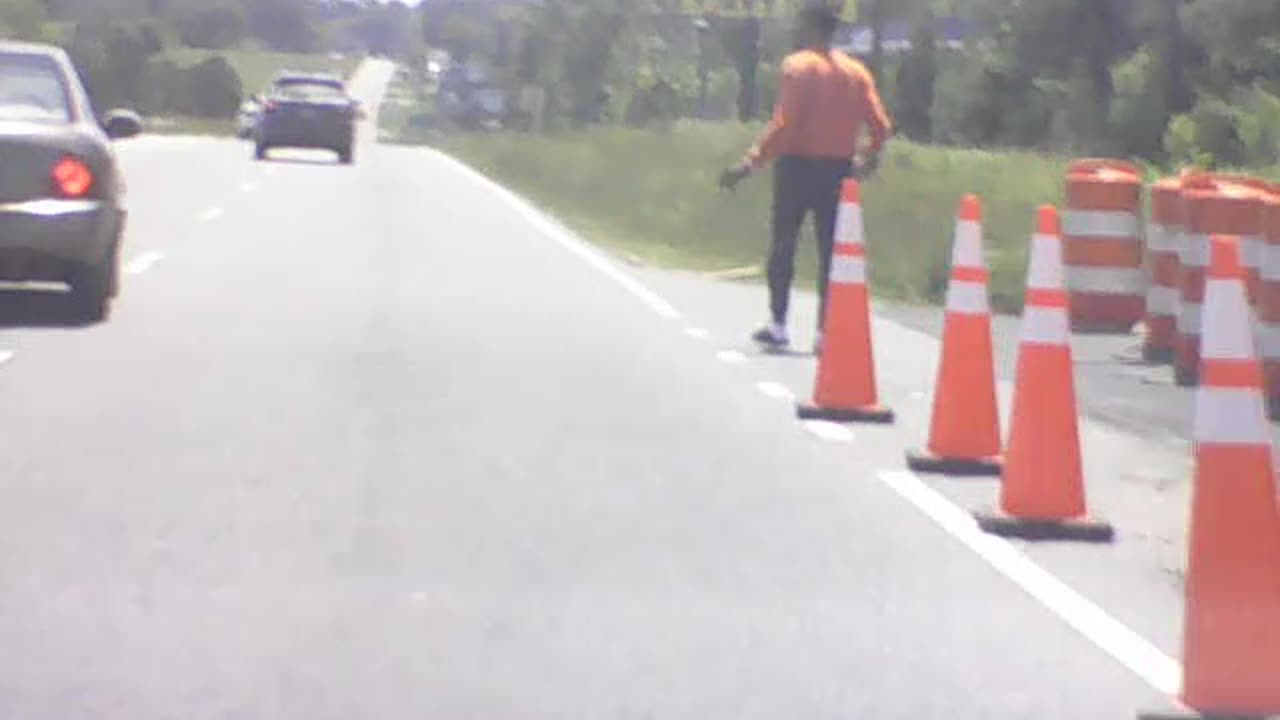 Maniac flings cone into traffic