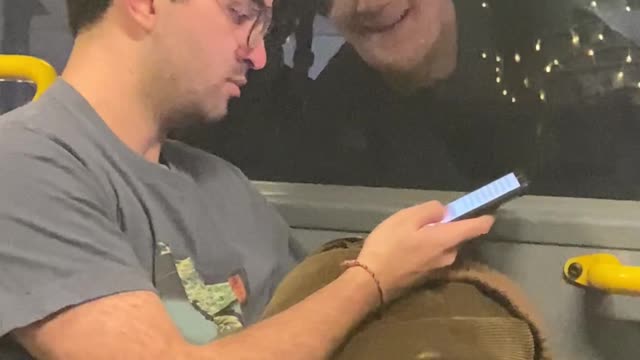 Bus Passenger Surprised to Find Someone Outside Reading Over His Shoulder