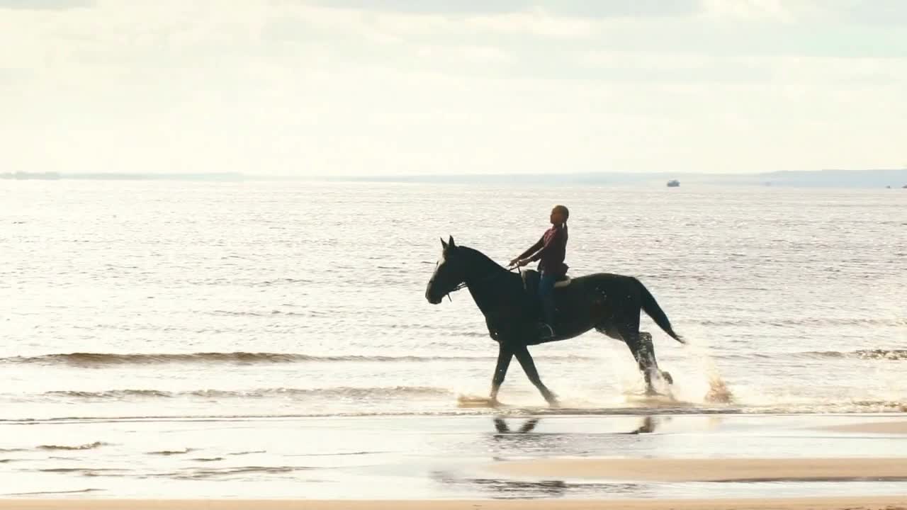 girl riding a horse along the coast