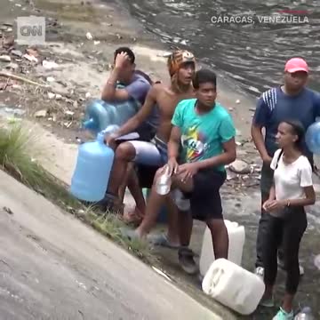 Venezuelans collecting water from drainage pipes