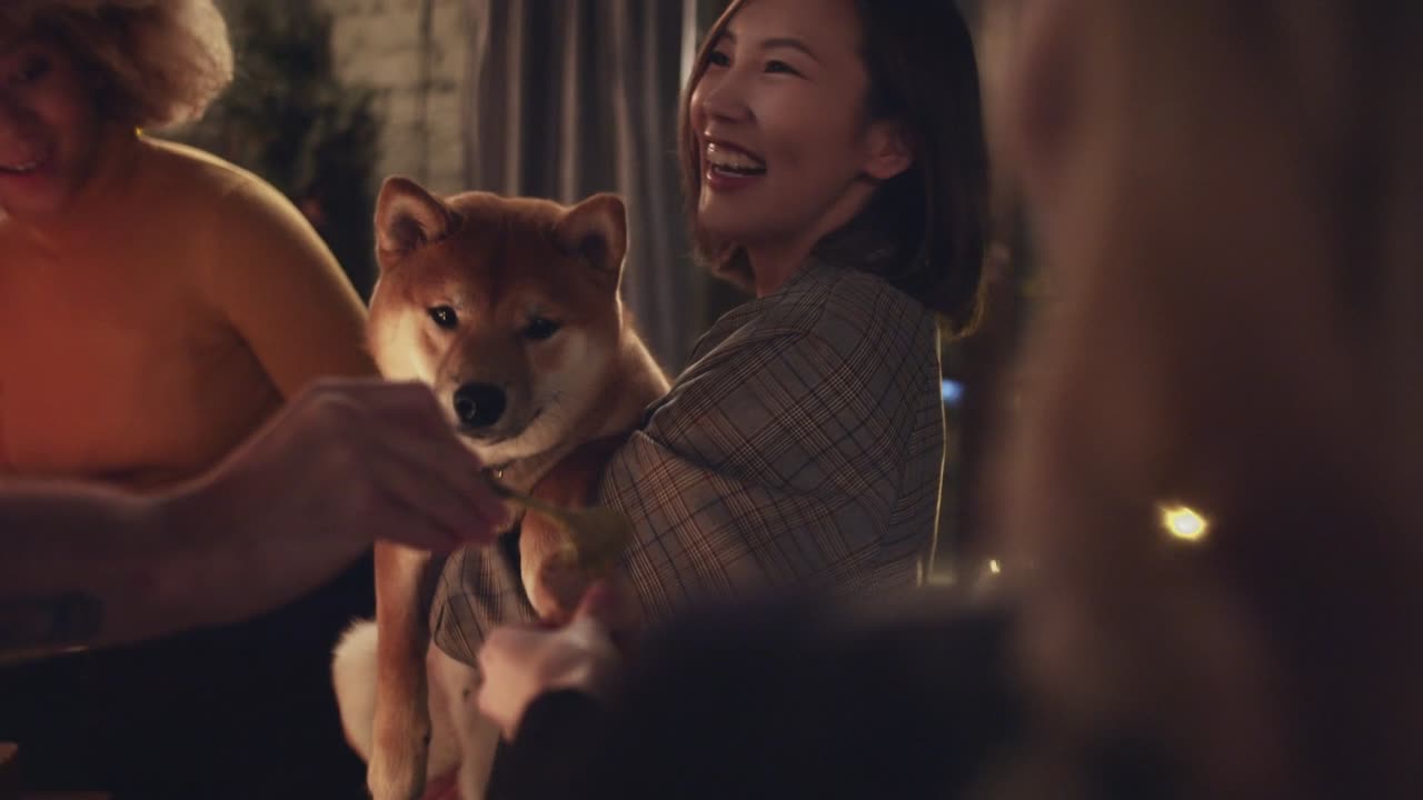 A Group Of People Teasing A Pet Dog With Bread For Food