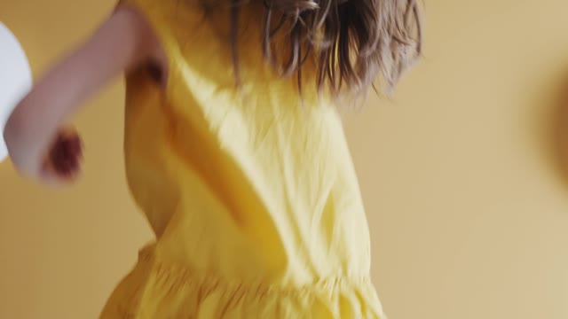 A Young Girl Jumping Up And Down On A Bed