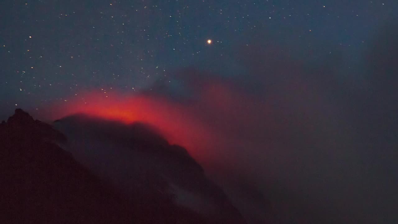 Active volcano smoking during the starry night - Free Stock Video