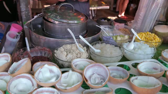 A vendor sells coconut ice cream to customers in Thailand
