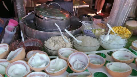 A vendor sells coconut ice cream to customers in Thailand