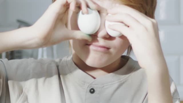 A Boy Playing With Eggs By Putting It Over His Eyes
