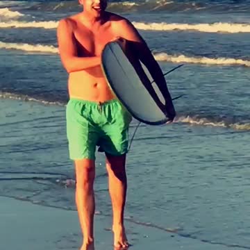 Surfer takes knee on beach