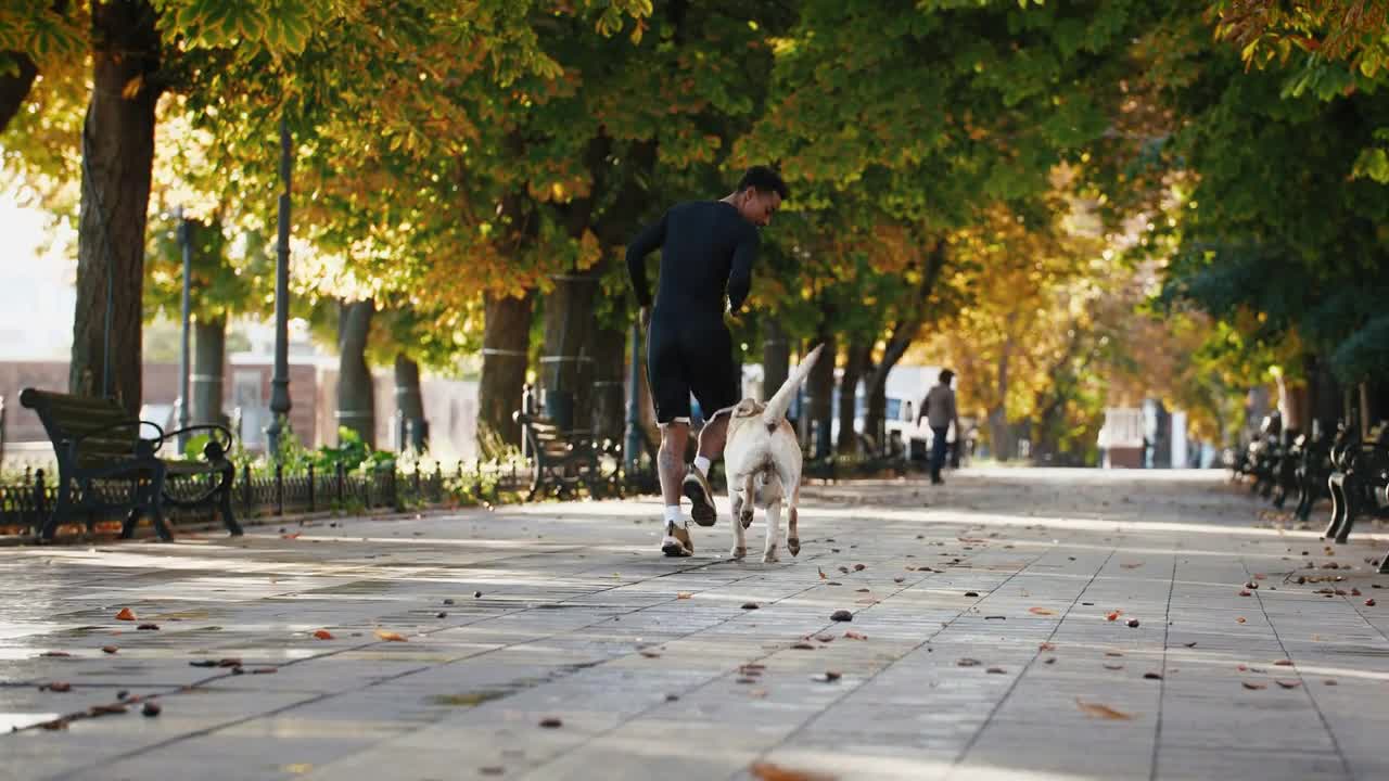 Young black man running with his white labrador dog