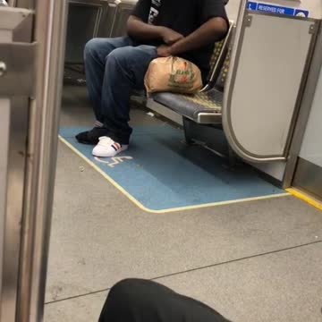 Man in black shirt and skeleton mask on subway train