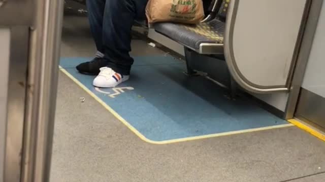 Man in black shirt and skeleton mask on subway train