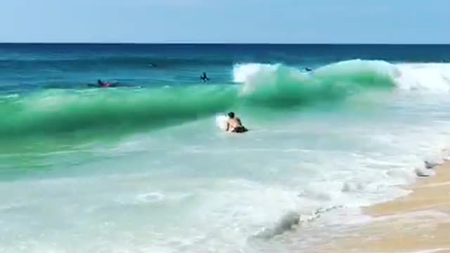 Guy surfboard runs into ocean beach hit by big wave