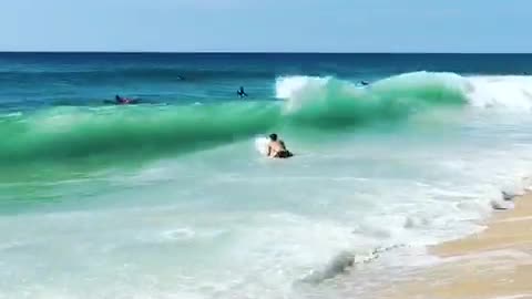 Guy surfboard runs into ocean beach hit by big wave