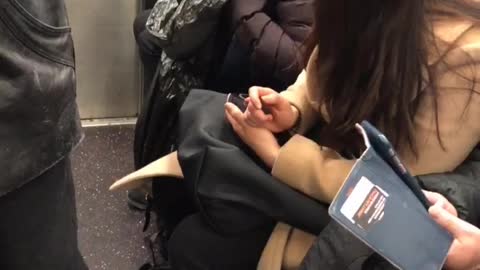 Woman on nyc subway train throws up into black plastic bag