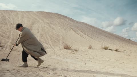 Man Sweeping Sand on a Desert