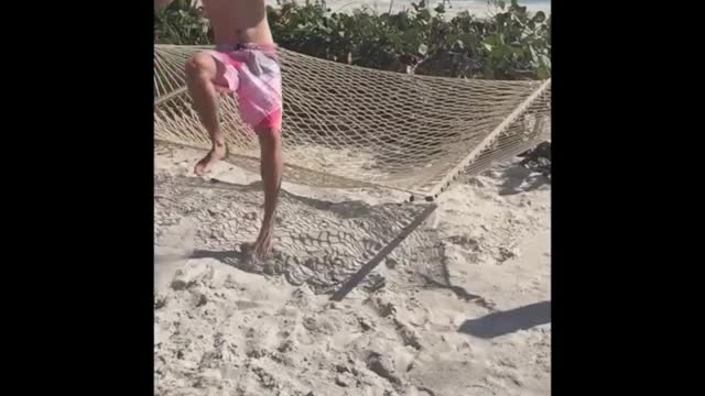 Beach hammock slomo man fall off