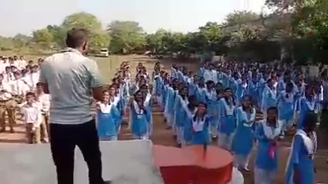 Morning exercise in Indian school with sports teacher and student