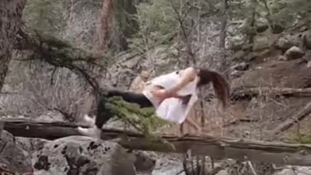 Teenage Girl Falls into a waterfall doing yoga on tree branch