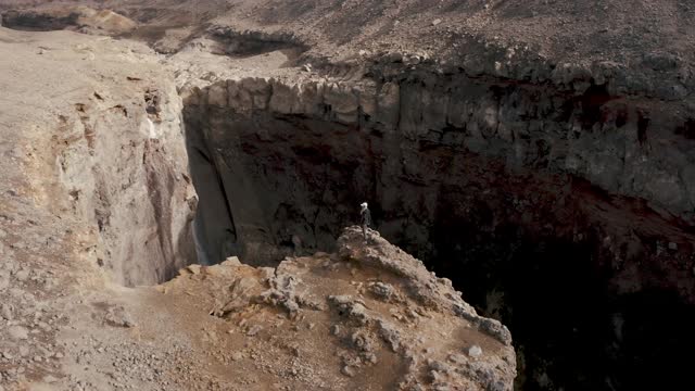 Woman Standing on the Edge of a Cliff