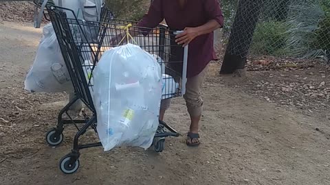 Homeless Man Rides Cart to Collect Cans