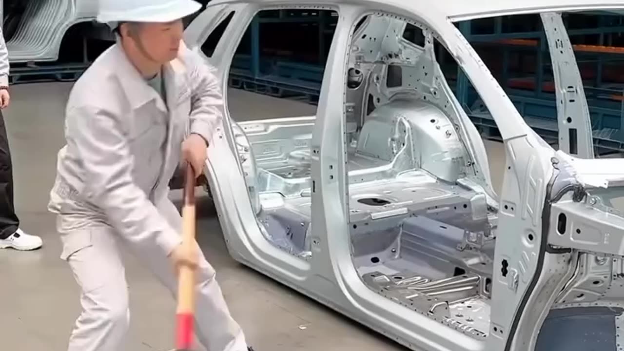 Worker smashing a car in the factory