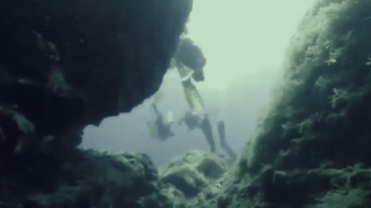 Scuba diver swims between one of the oldest rocks in the world