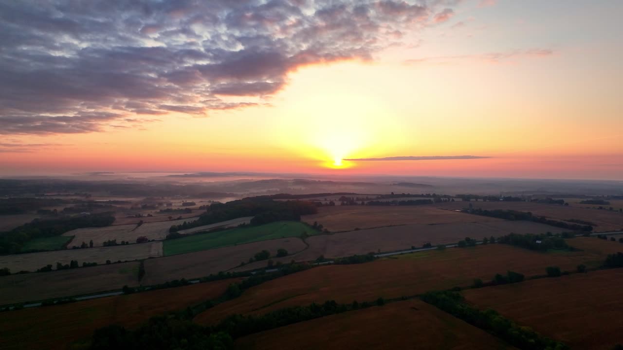 Beautiful mist enshrouds farmland at sunrise, captured from the air