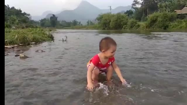 Baby playing in the river