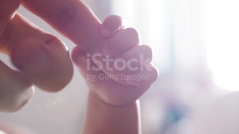 Newborn baby holding mother's hand