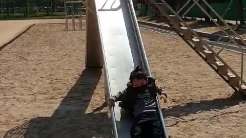 This is a video of a baby having fun on a slide.