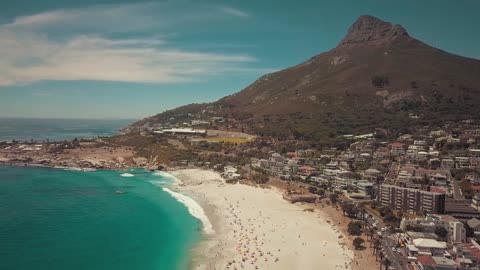 A Crowd Of People Out And Enjoying The Beach On A Sunny Day