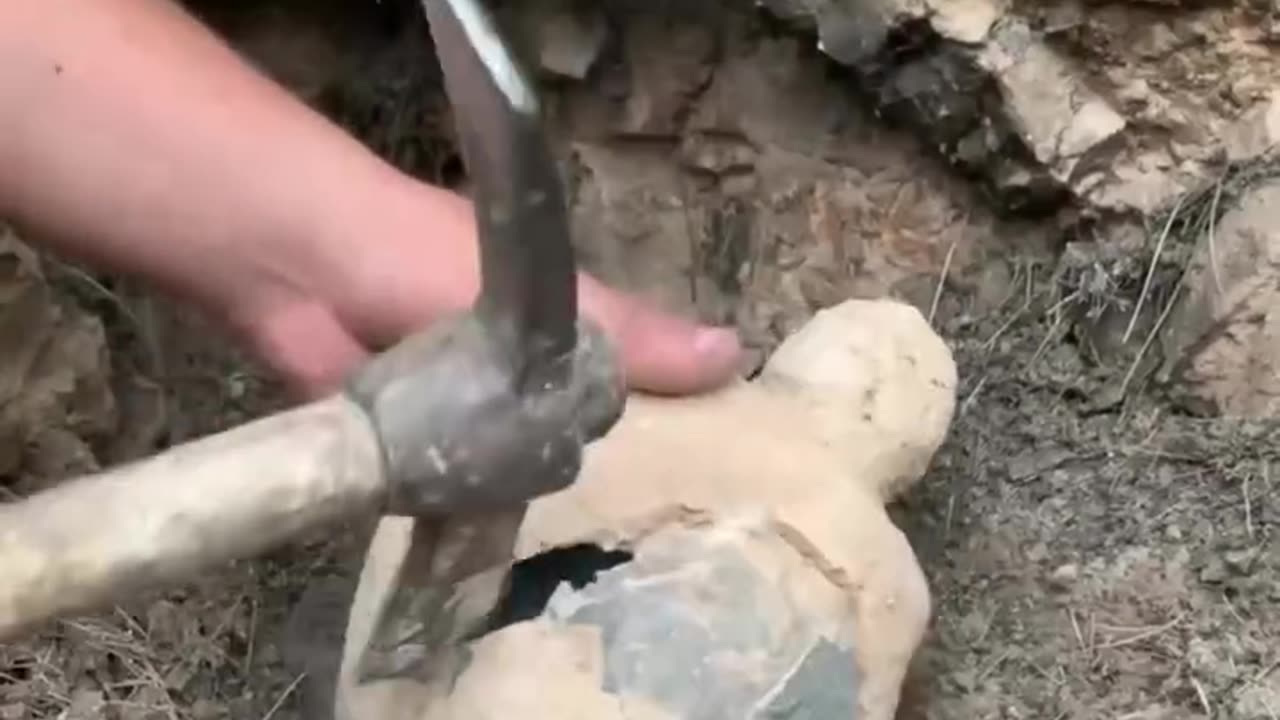 Person is cracking open a clay pot