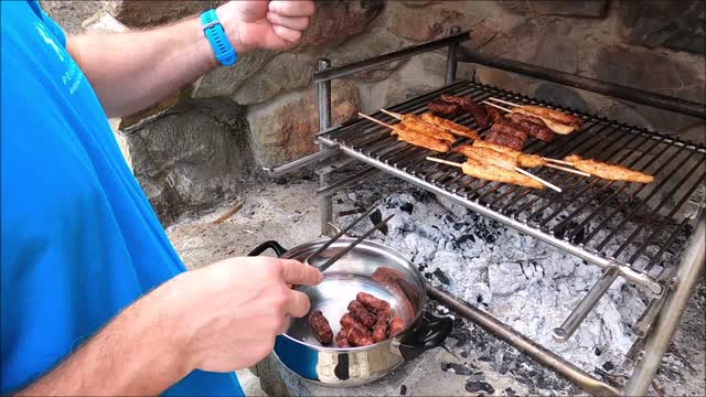 Man Cooking Sausages On The Grill