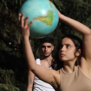 A Woman Dancing While Holding a Globe