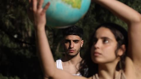 A Woman Dancing While Holding a Globe