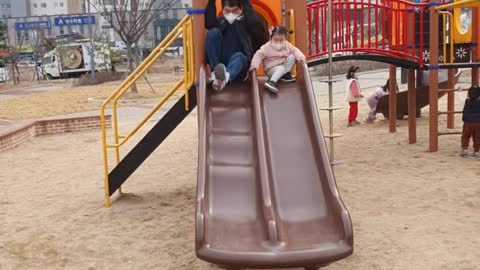 Dad and daughter ride on the slide