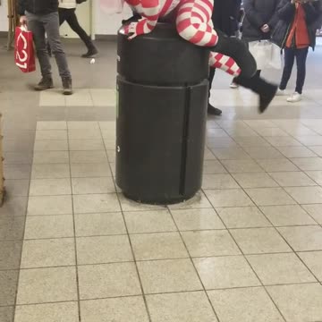 Person in donald trump mask, american flag bodysuit climbs on top trash can