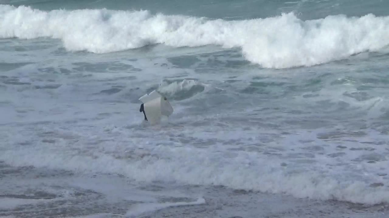 Wetsuite guy tries to surf with broken white surfboard