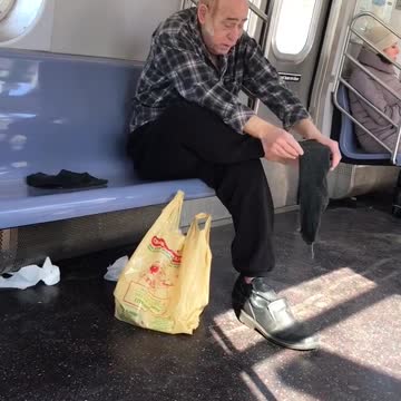 Man rubs bare foot on subway train