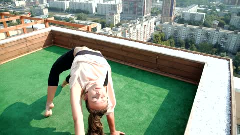 Yoga girl doing poses on a rooftop