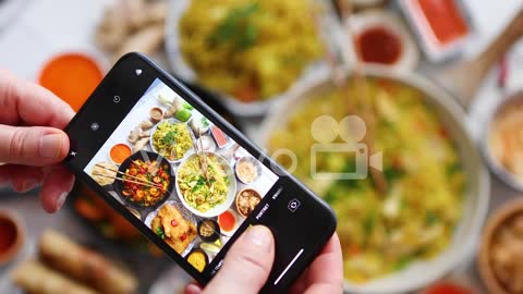 Woman taking a photo with her smartphone Ready for social media Asian food concept