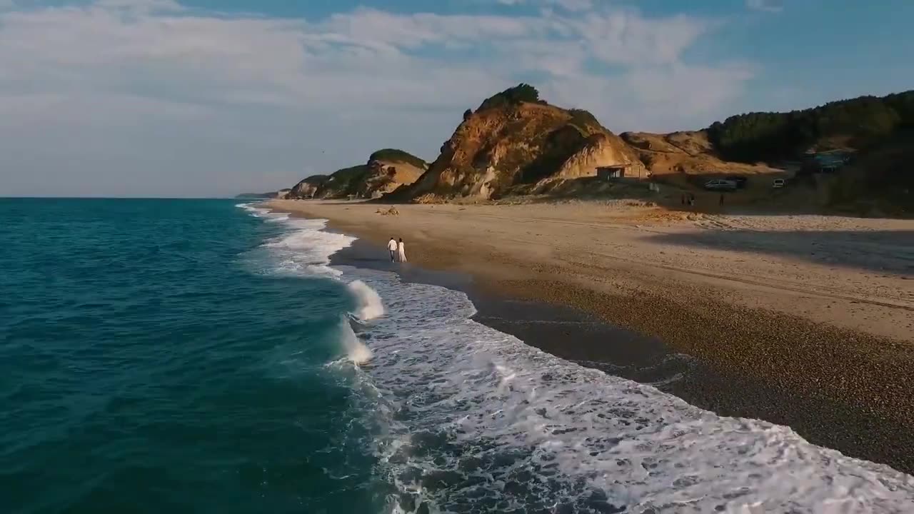 Free footage of a happy couple walking at the beach