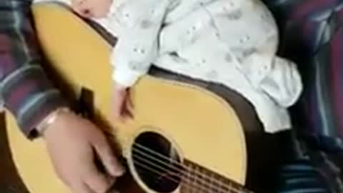 Little girl sleep's on the guitar while father play!